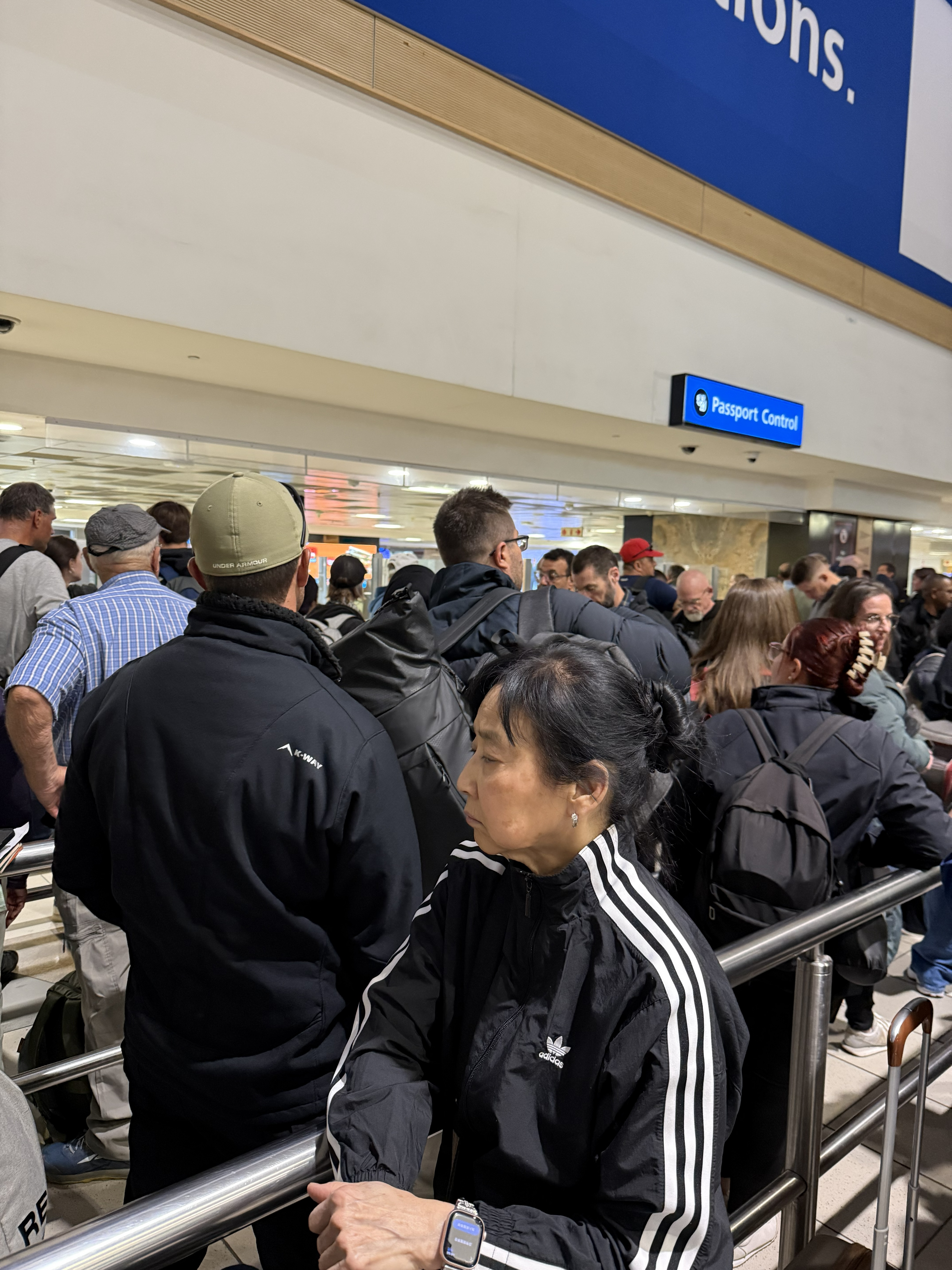 Passport control. Five booths, two officers, and the entire flight in a single line behind us.