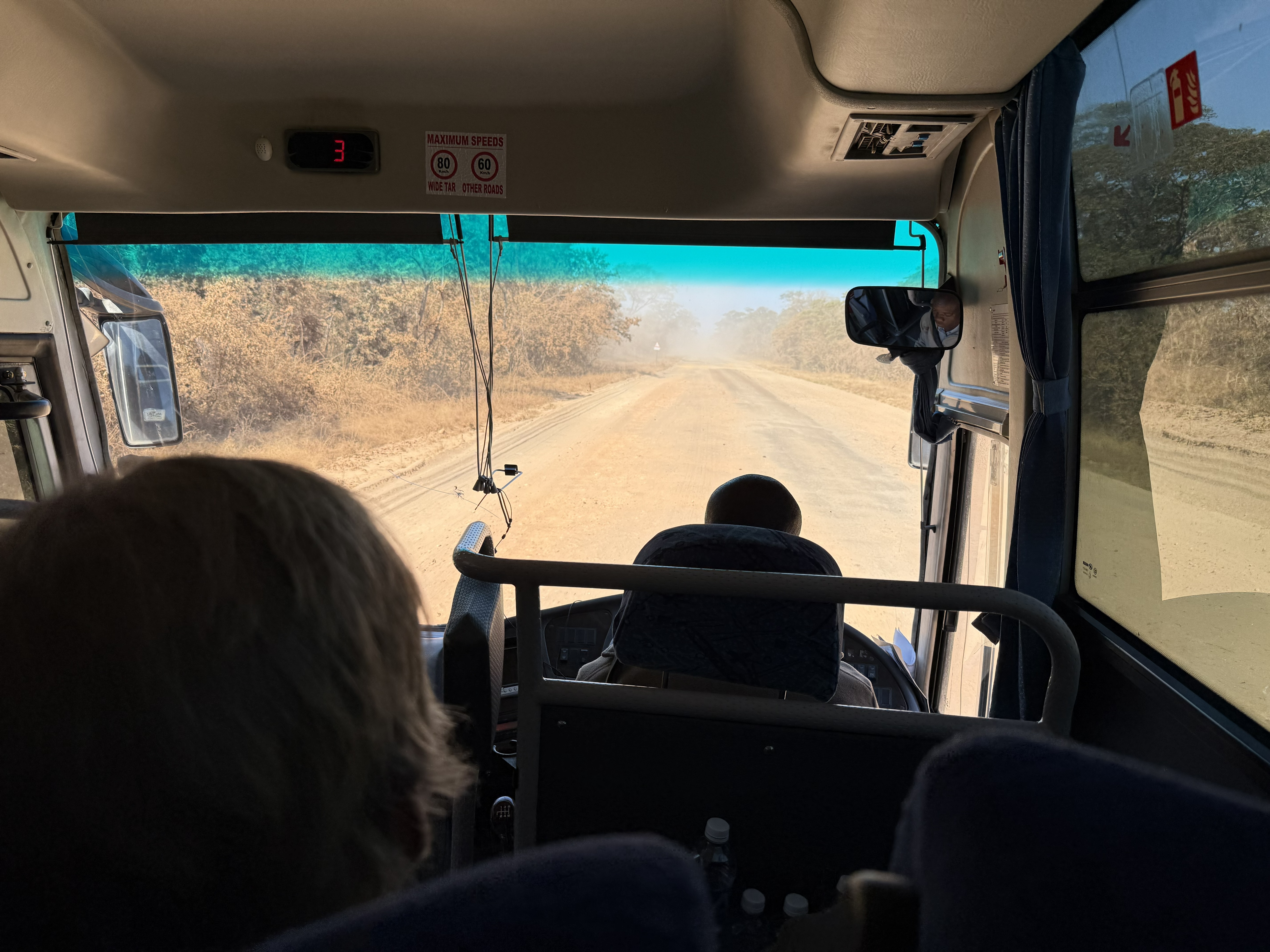 The road to Hwange, from the front of the coach. Not the worst stretch, but for what counts as a major road here it is a dust track. The sign allows 80 on wide tar and 60 on “other