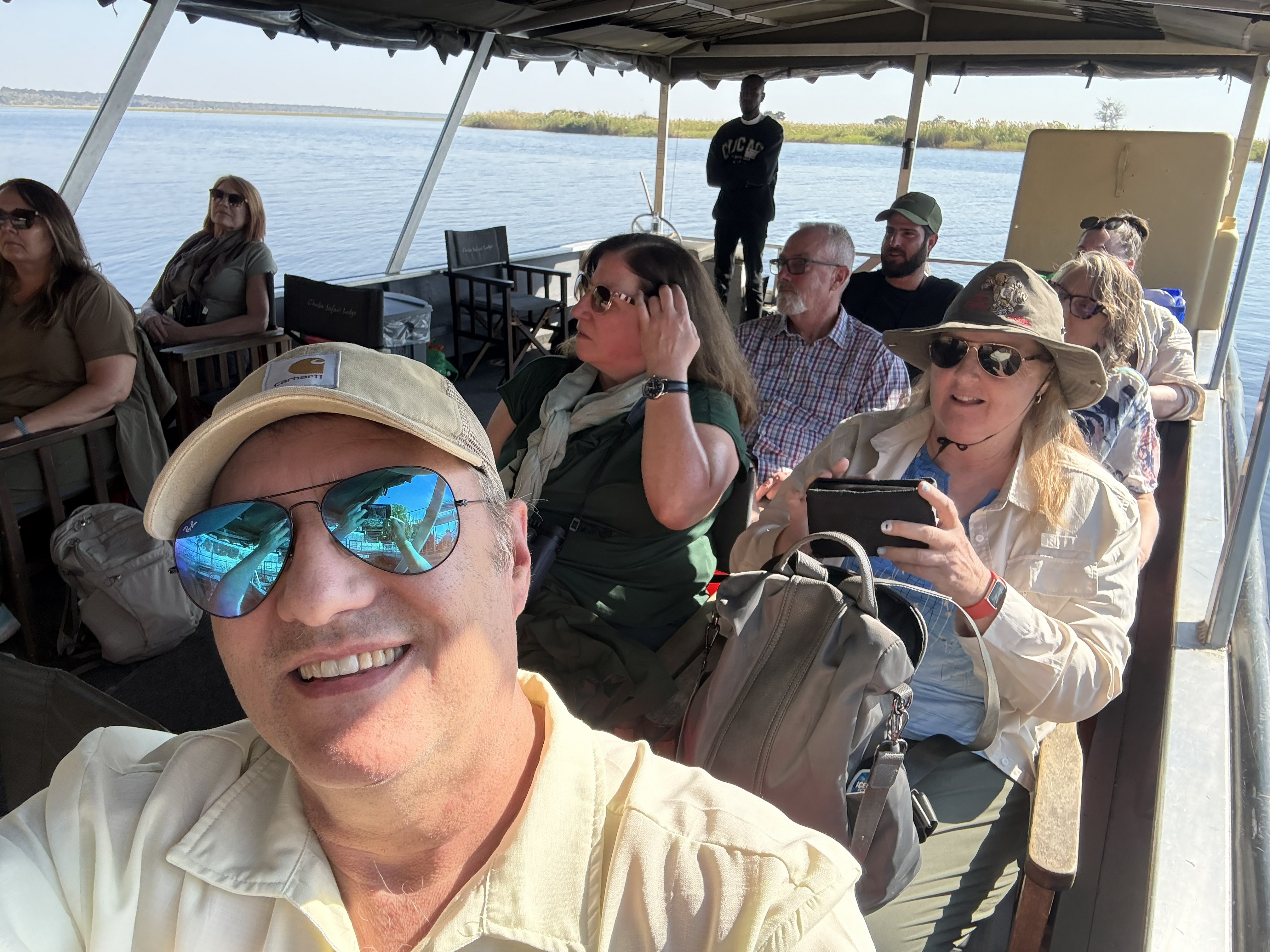 The group aboard, sun hats and long lenses and the particular good cheer of people who have realised the afternoon is going to be easy.